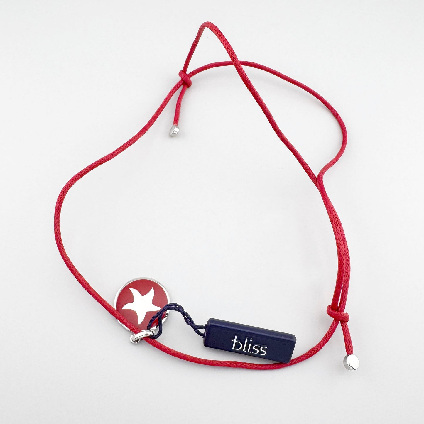 Collier avec ancre émaillée rouge posé à plat, ligne épurée