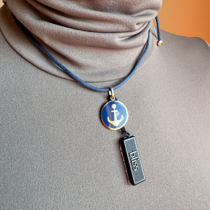 Anchor pendant necklace with blue enamel worn on a navy cord