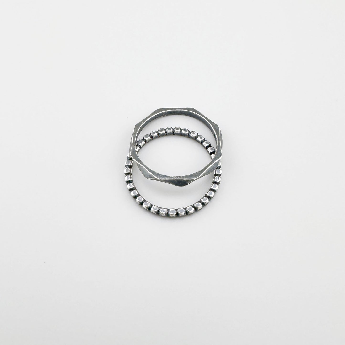 Anillo de plata 925 con patrón de bolitas, pátina suave y línea minimalista sobre fondo claro