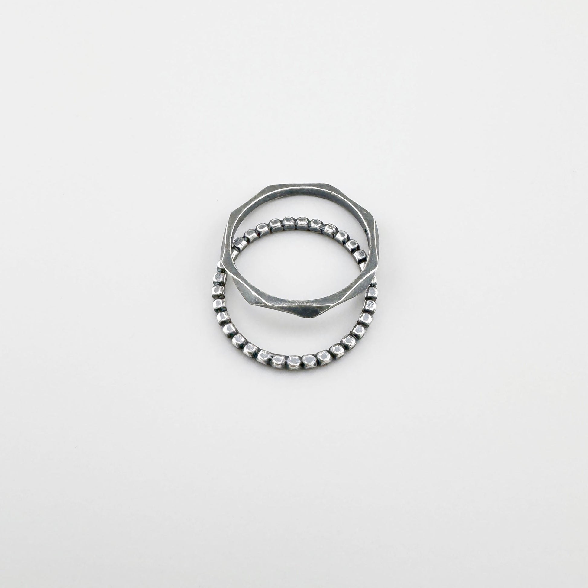 Anillo de plata 925 con patrón de bolitas, pátina suave y línea minimalista sobre fondo claro