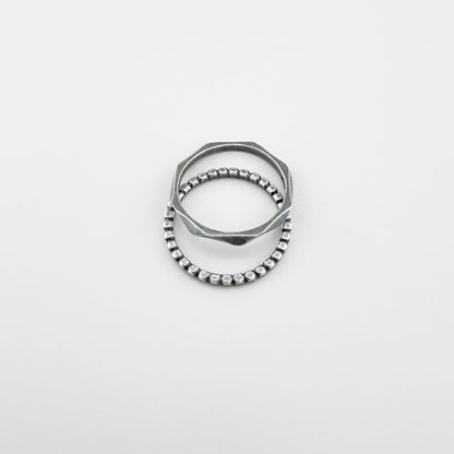 Anillo de plata 925 con patrón de bolitas, pátina suave y línea minimalista sobre fondo claro