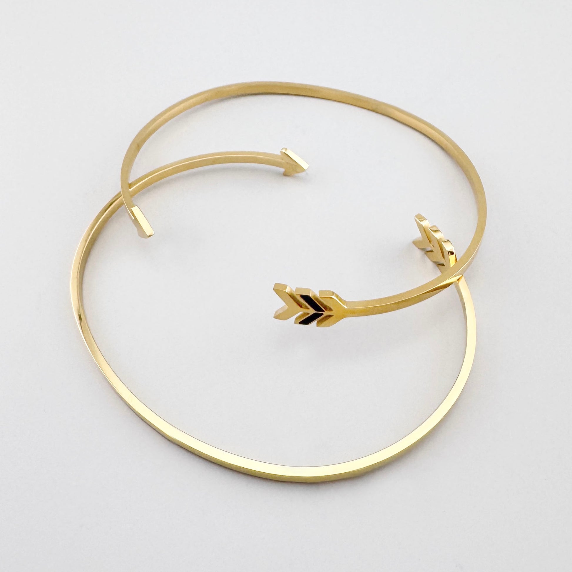 Bransoletka ze strzałą w złotym odcieniu jako symboliczny, nowoczesny akcent na nadgarstku