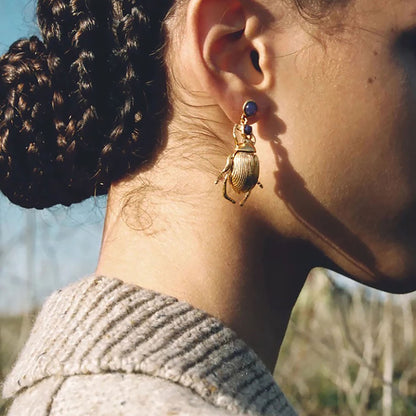 Beetle earrings Sonata worn on the ear with gold-tone detail and pink stones