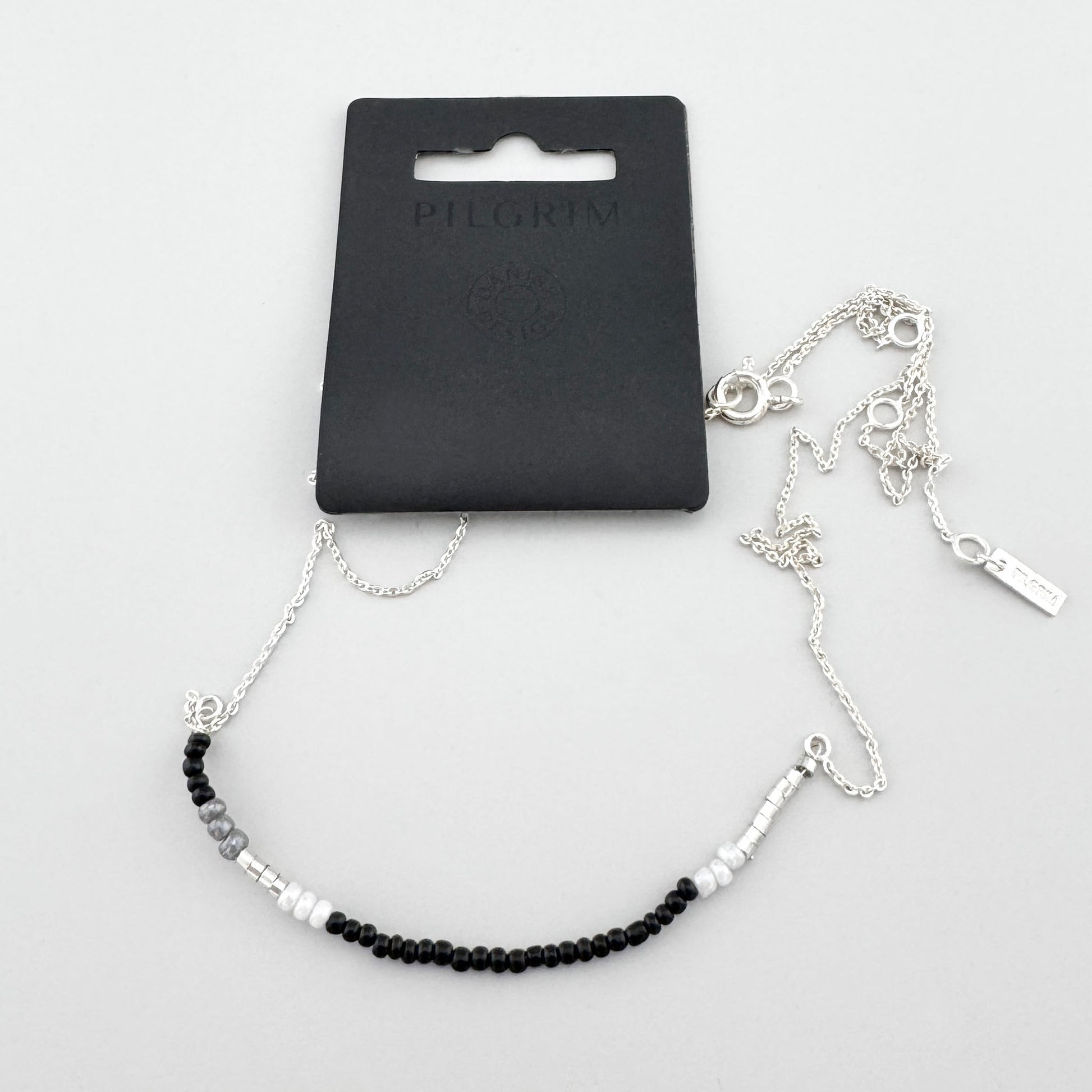 Collar minimalista con cuentas negras, blancas y grises y cadena brillante