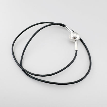 Czarny choker Thomas Sabo z dekoracyjną srebrną kulką i metalowymi końcówkami na jasnym tle