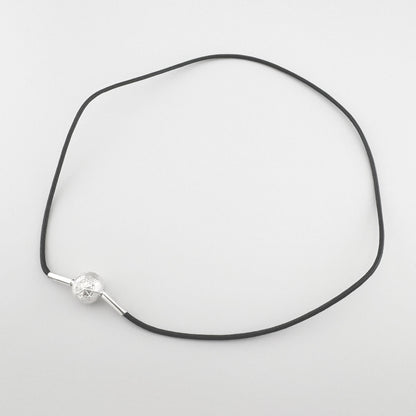 Schwarzer Choker von Thomas Sabo mit silberner Kompasskugel flach auf hellem Hintergrund