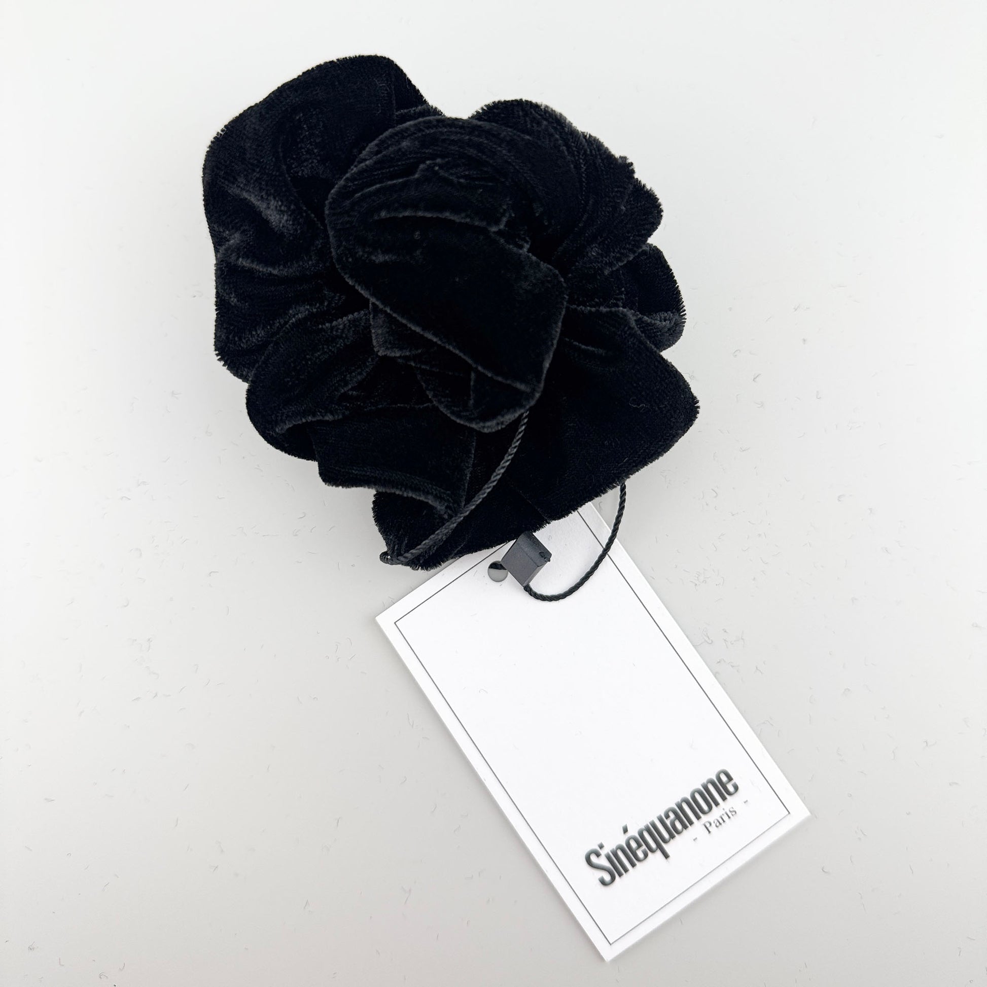 Schwarzer Samt-Scrunchie von Sinequanone Paris mit sichtbarem Markenetikett