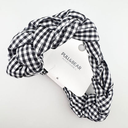 Black and white gingham Pull&Bear headband folded to show its braided shape and branded tag