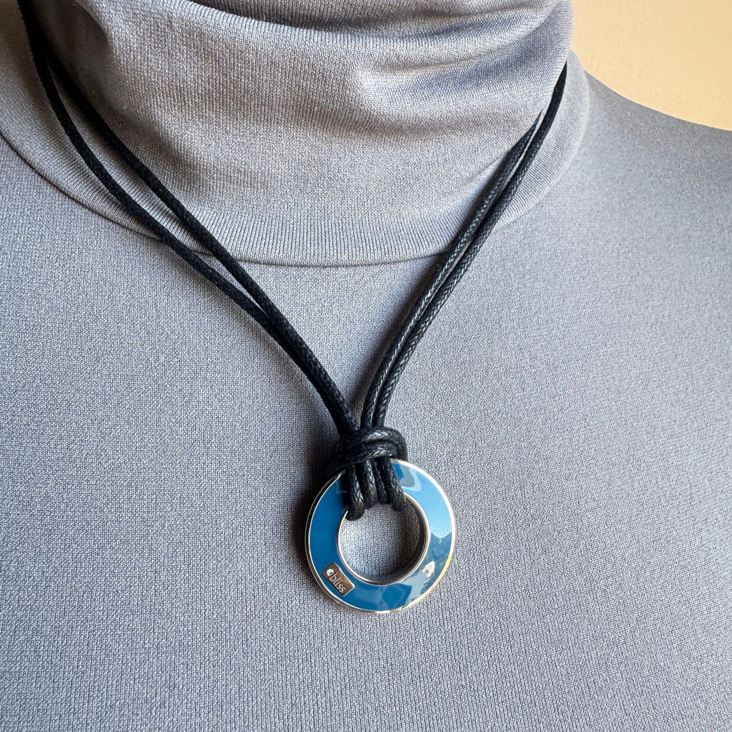 Wendbare Emaille-Halskette getragen, blauer Anhänger am schwarzen Band