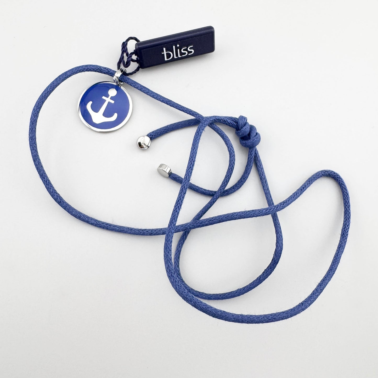 Collier avec ancre en émail bleu posé à plat sur fond clair