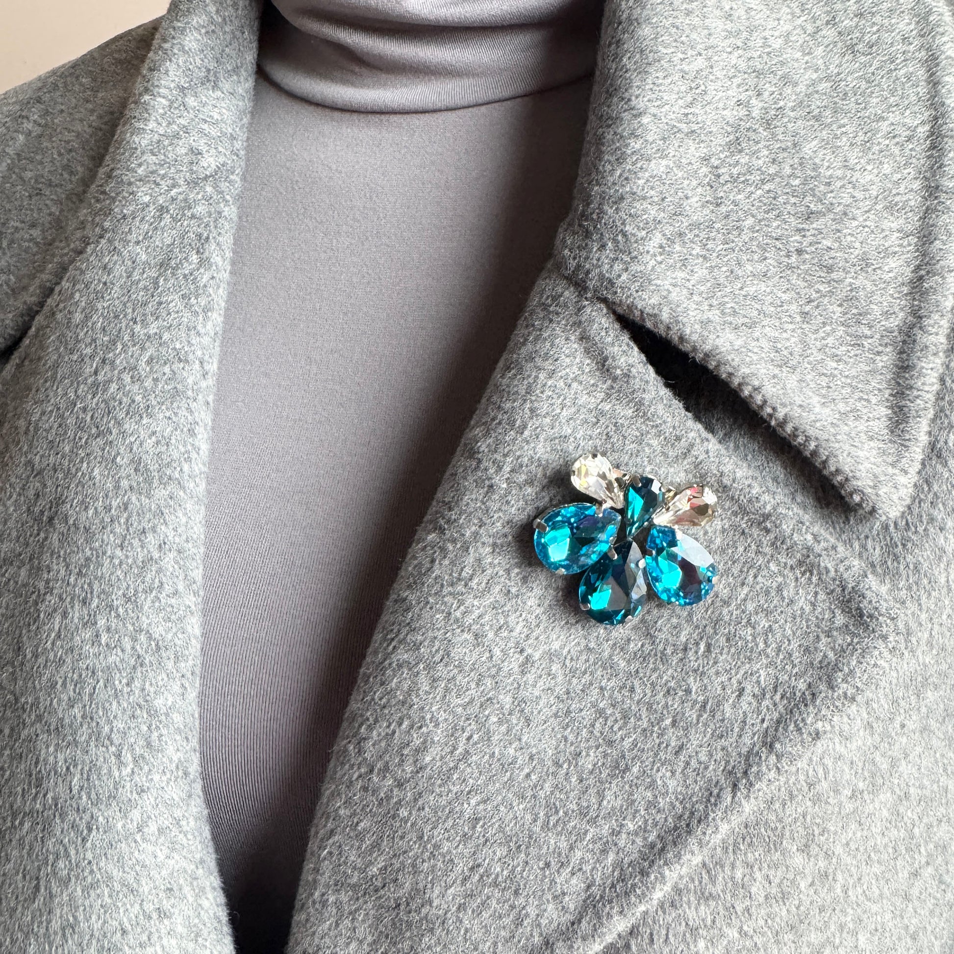 Elegant blue crystal brooch Sonata worn on a coat with a floral silhouette