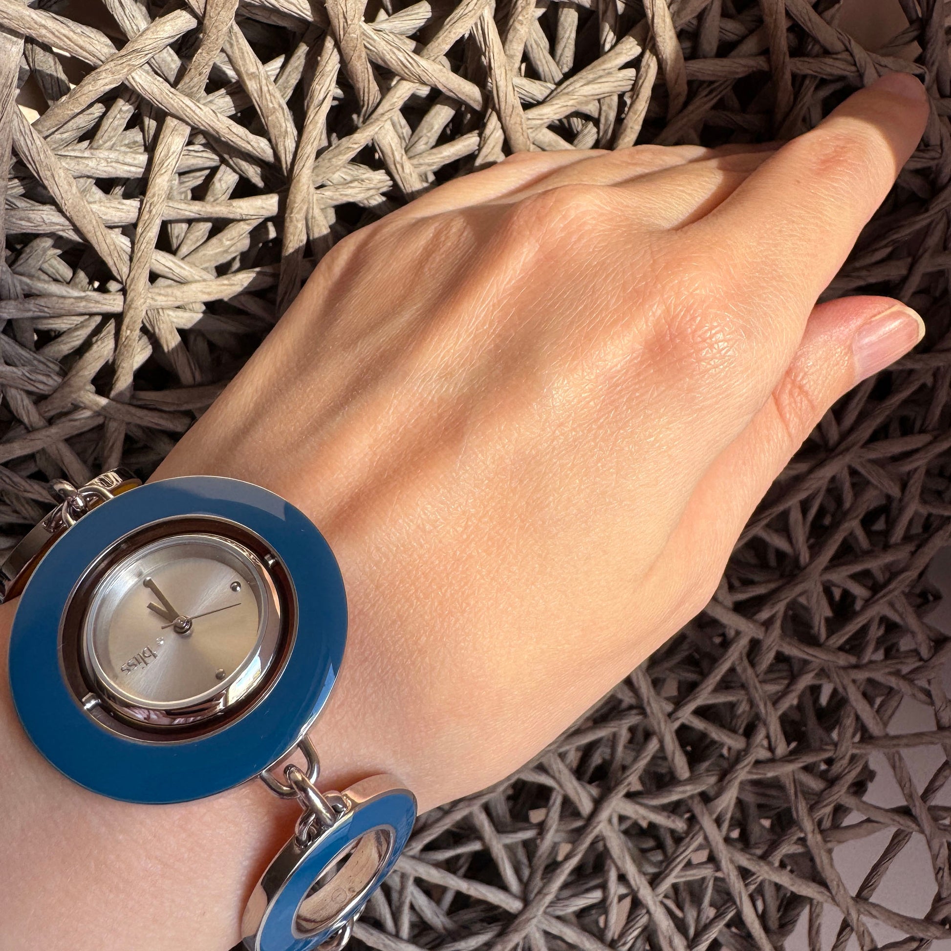 Dwustronny zegarek-bransoletka na nadgarstku z niebieską emalią