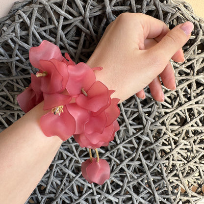 Romantisches Armband aus rosa Blütenblättern am Handgelenk