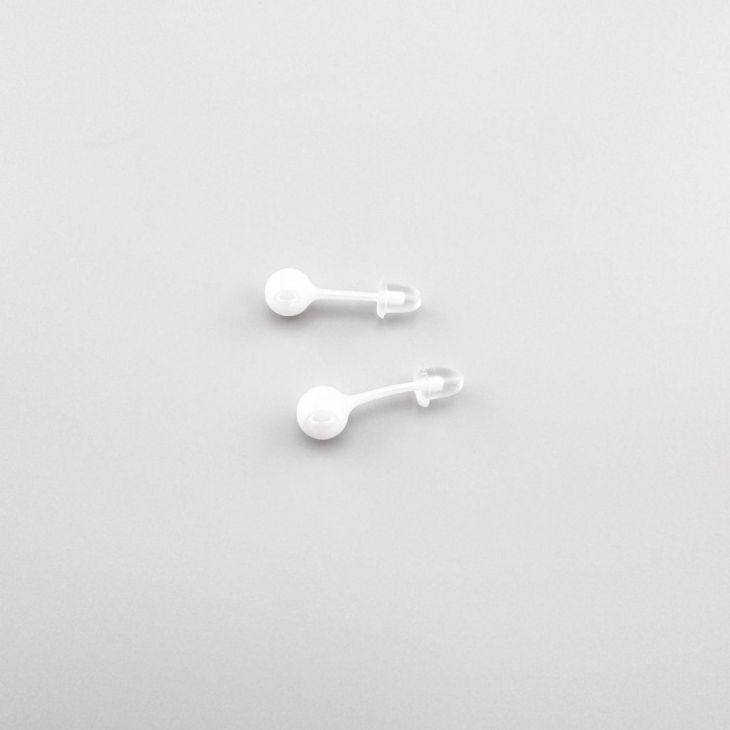 Boucles d’oreilles puces Sonata en céramique blanche avec forme discrète et polie