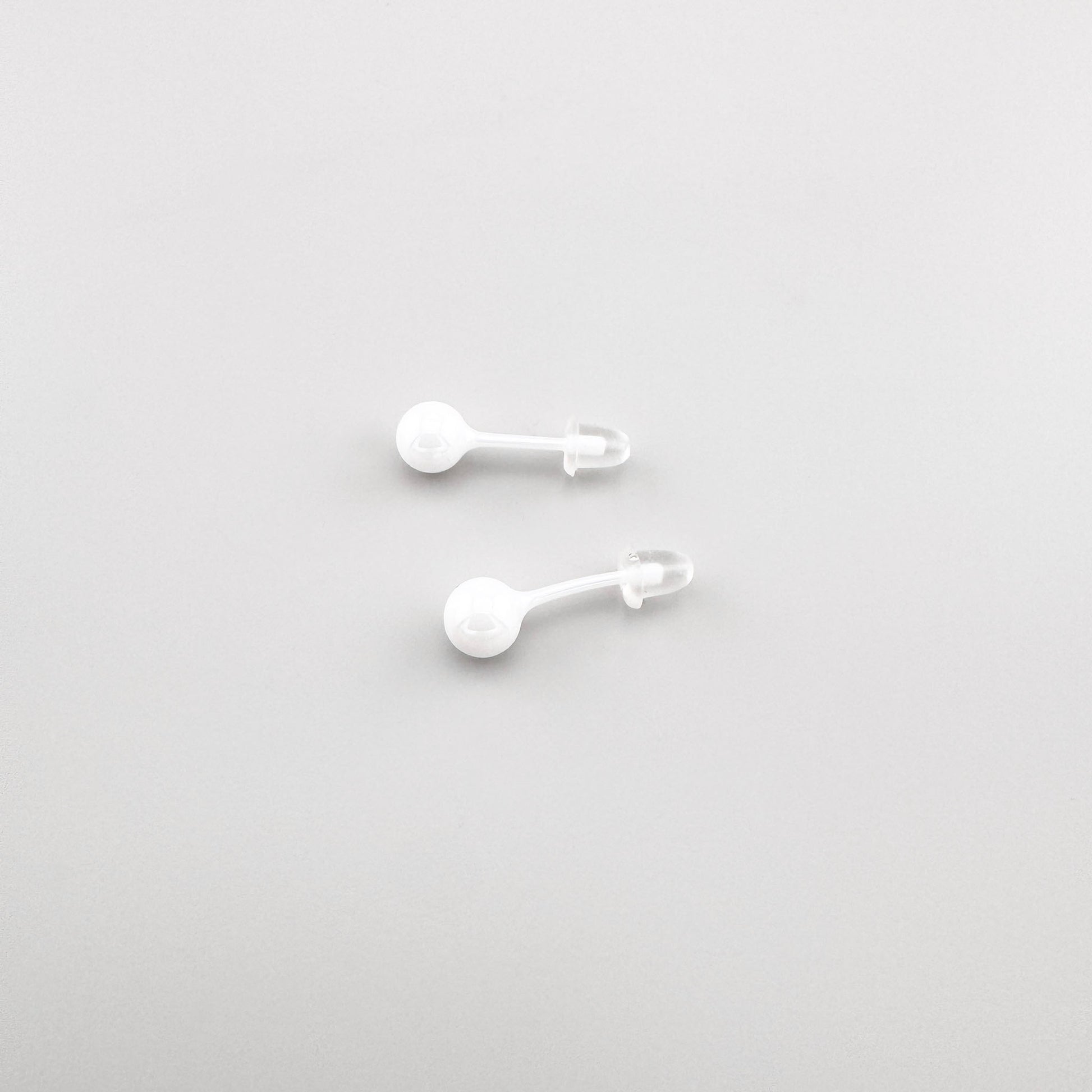 Boucles d’oreilles puces Sonata en céramique blanche avec forme discrète et polie