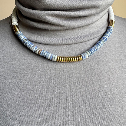 Gray-blue sodalite necklace with matte white discs and gold accents, minimalist style by Ikita.