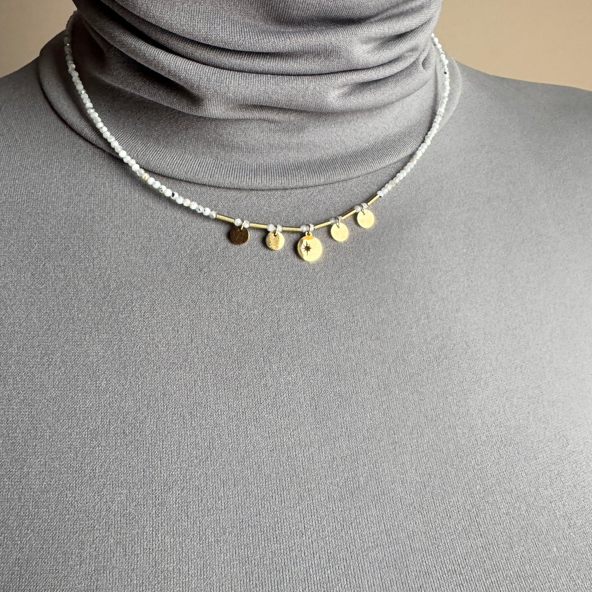 Delicate charm necklace IRL worn close to the neck with gold-tone pendants