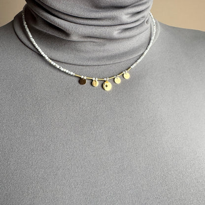 Delicate charm necklace IRL worn close to the neck with gold-tone pendants