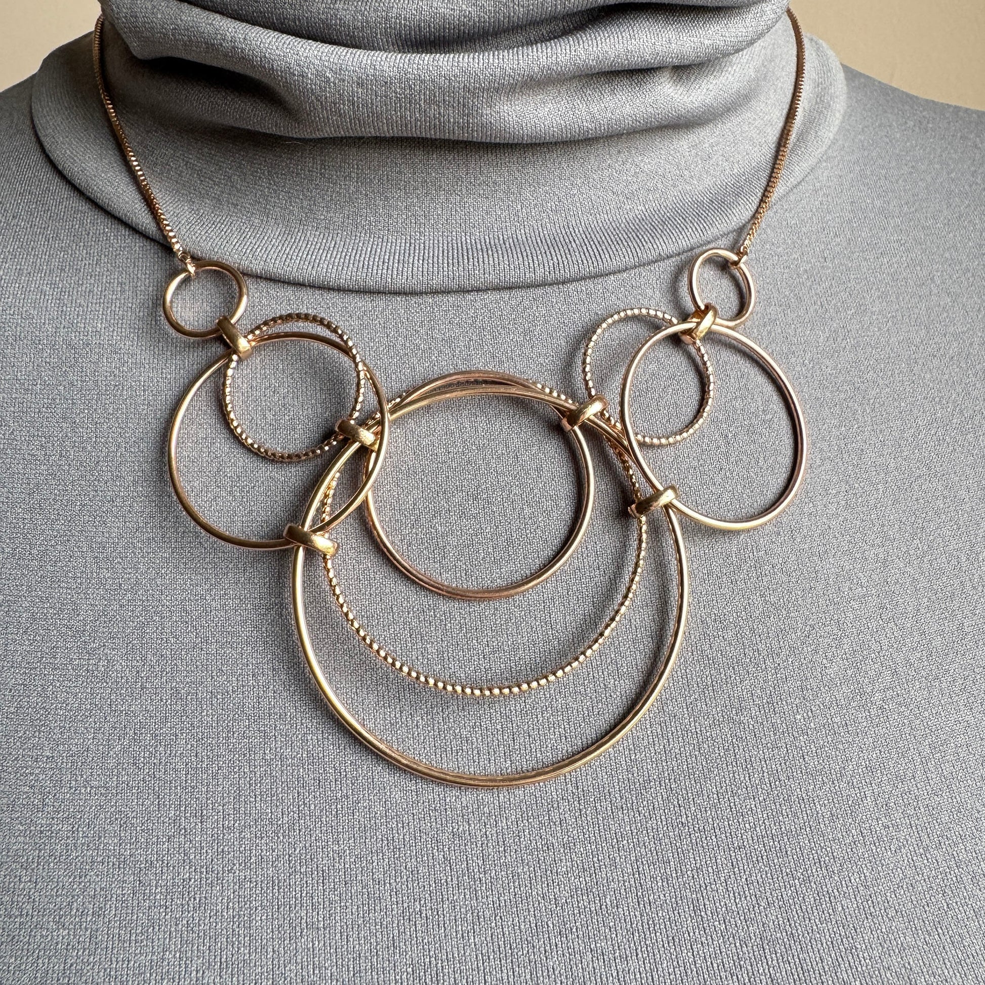 Gold-tone circle chain necklace worn on the neck with adjustable length