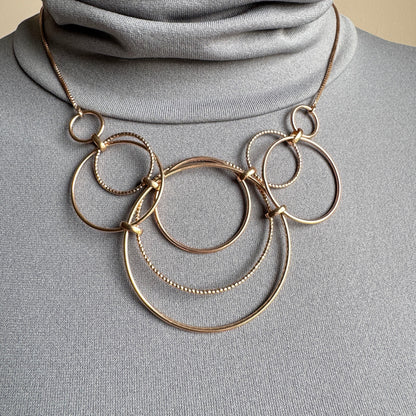 Gold-tone circle chain necklace worn on the neck with adjustable length