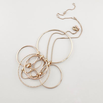 Collar dorado con círculos grandes enlazados en diseño moderno