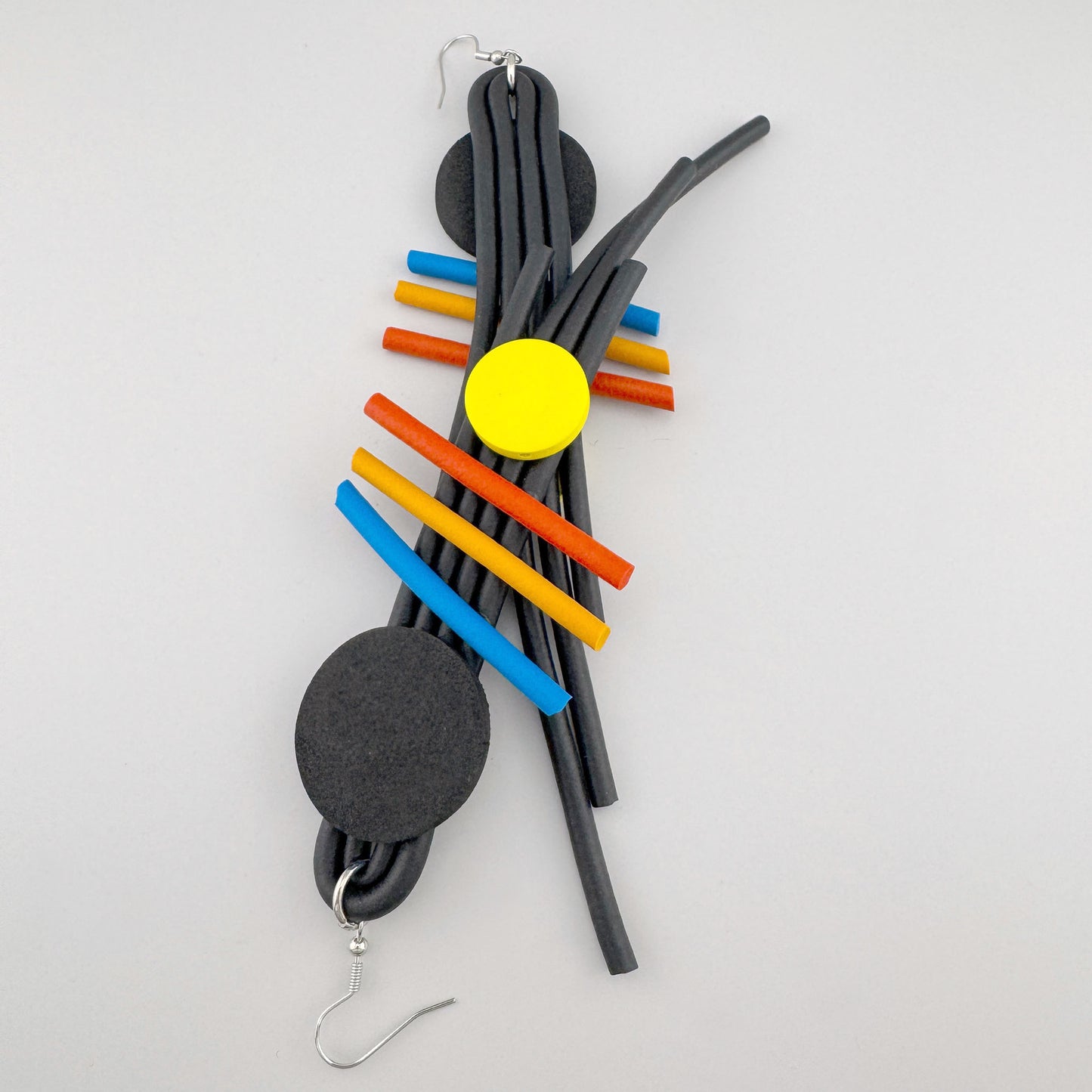 Geometrische Ohrringe Sonata mit bunten Staben auf schwarzer Form