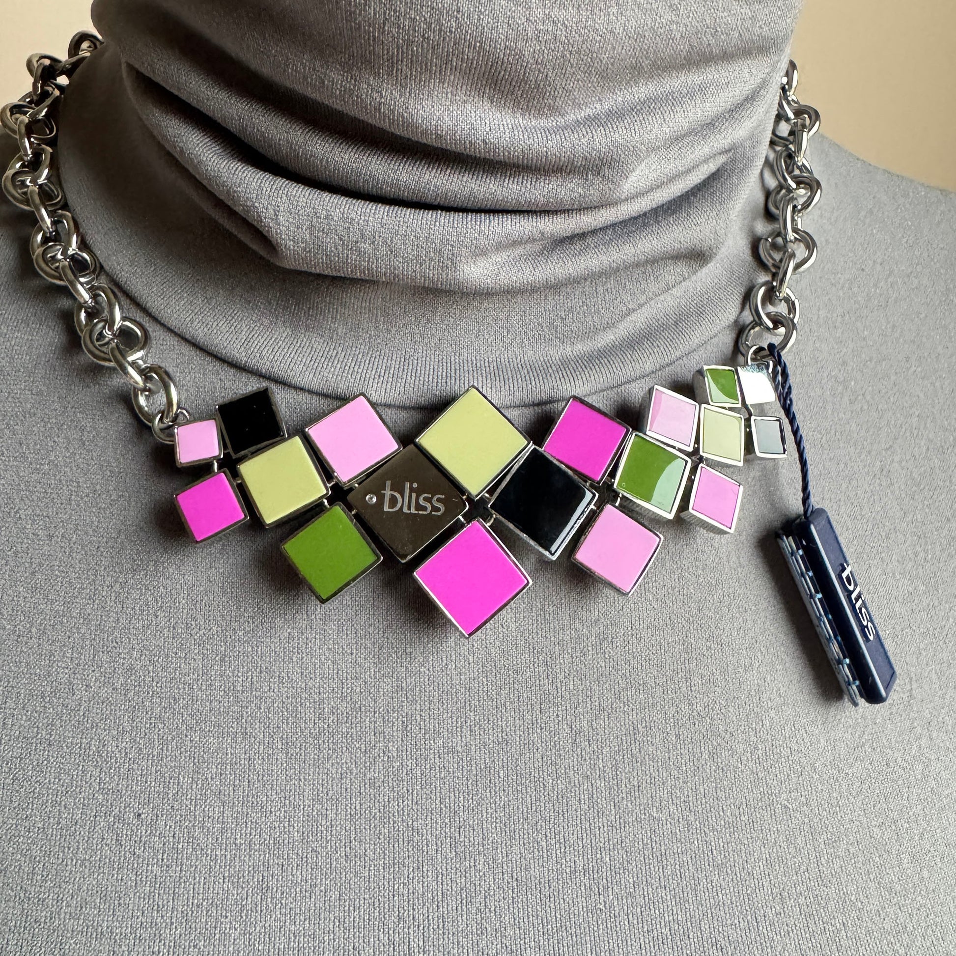 Color square necklace worn at the neck with bright geometric tiles