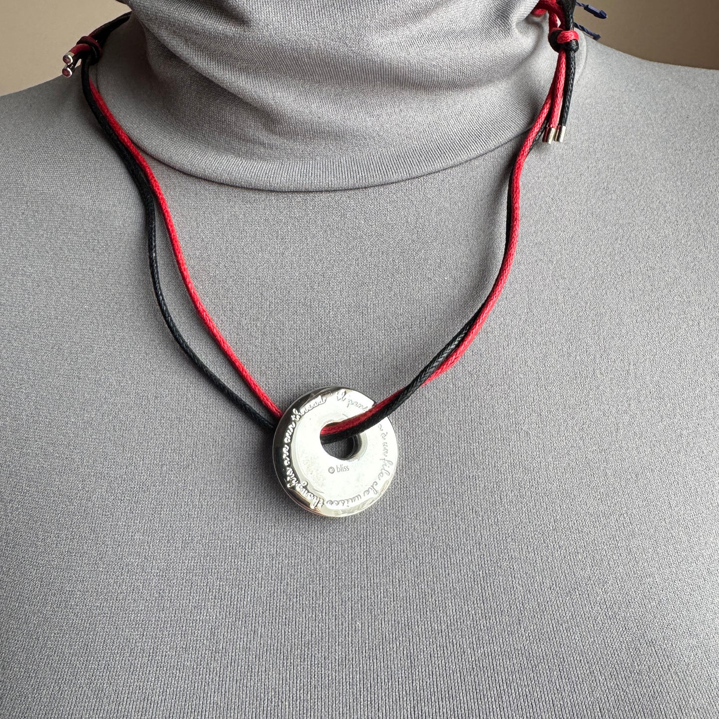 Cord necklace Bliss Gioielli worn with a silver pendant and contrasting red and black cords