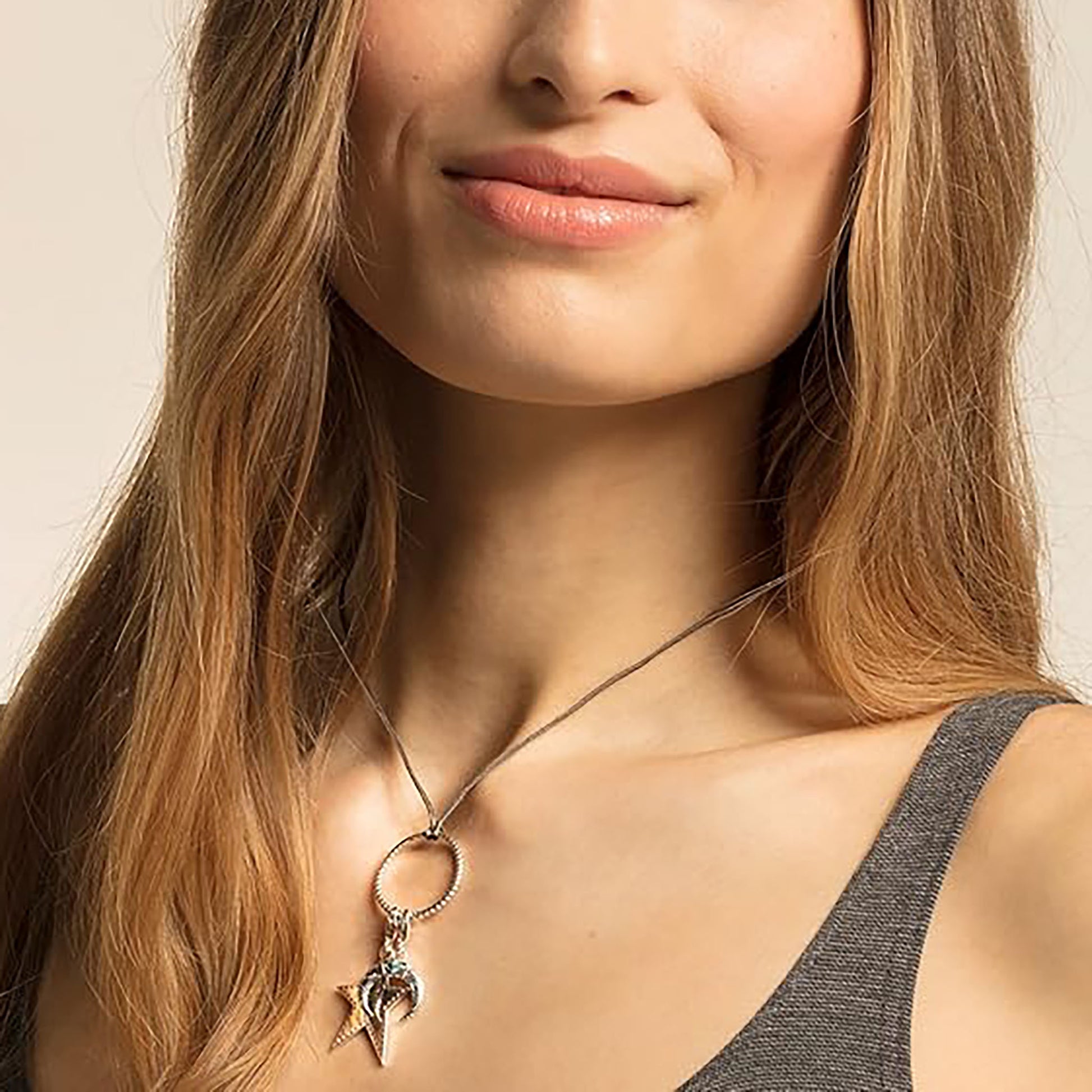 Silver crescent moon charm Thomas Sabo worn on a necklace with a turquoise accent