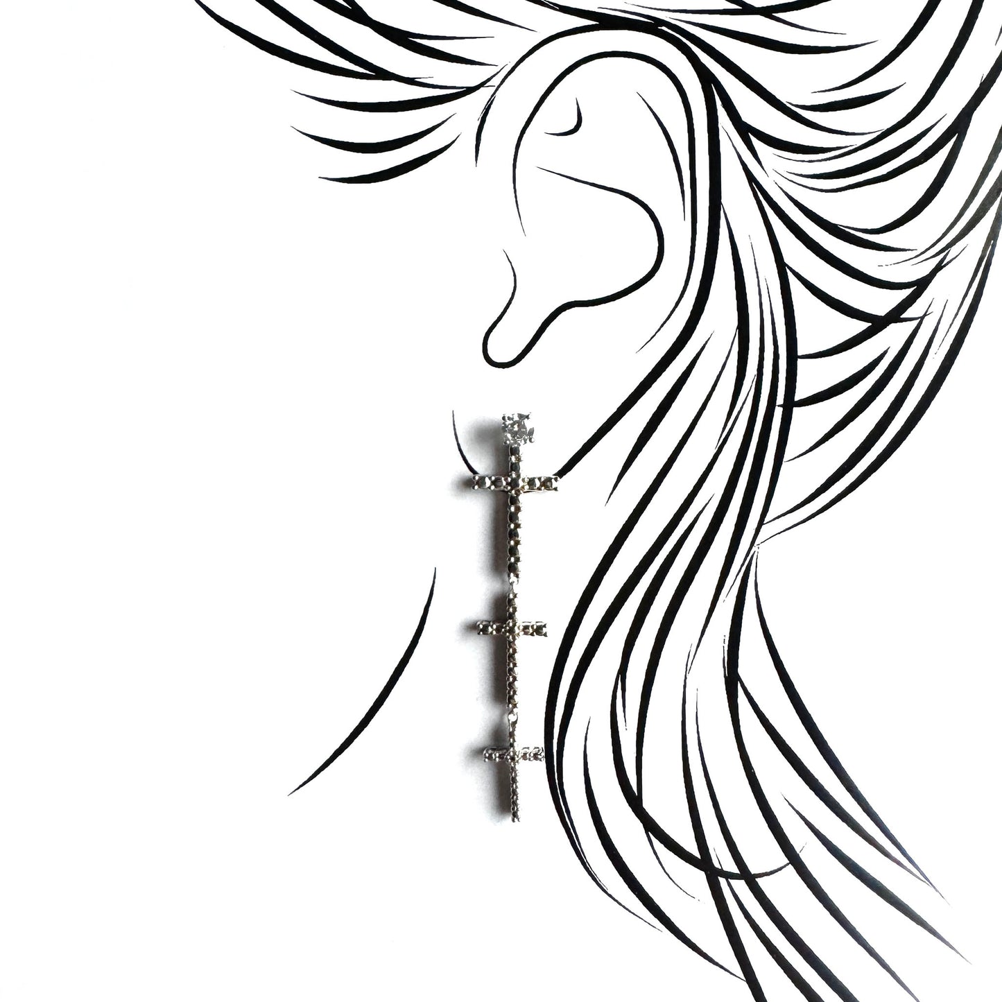 Silver cross earring shown on the ear with a long symbolic drop