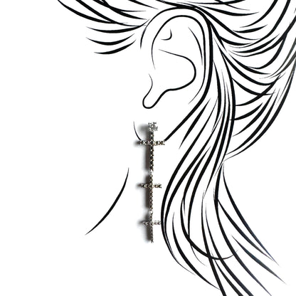 Silver cross earring shown on the ear with a long symbolic drop