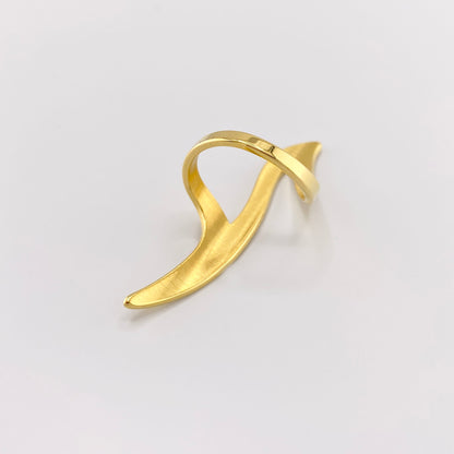 Gebogener Ring in Goldoptik mit moderner, abstrakter Wellenform aus Seitenansicht