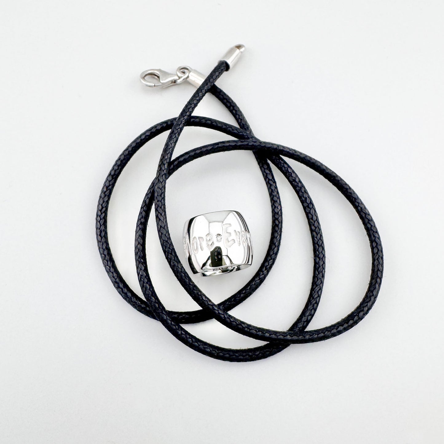 Naszyjnik z cylindryczną zawieszką na czarnym plecionym sznurku o minimalistycznym charakterze