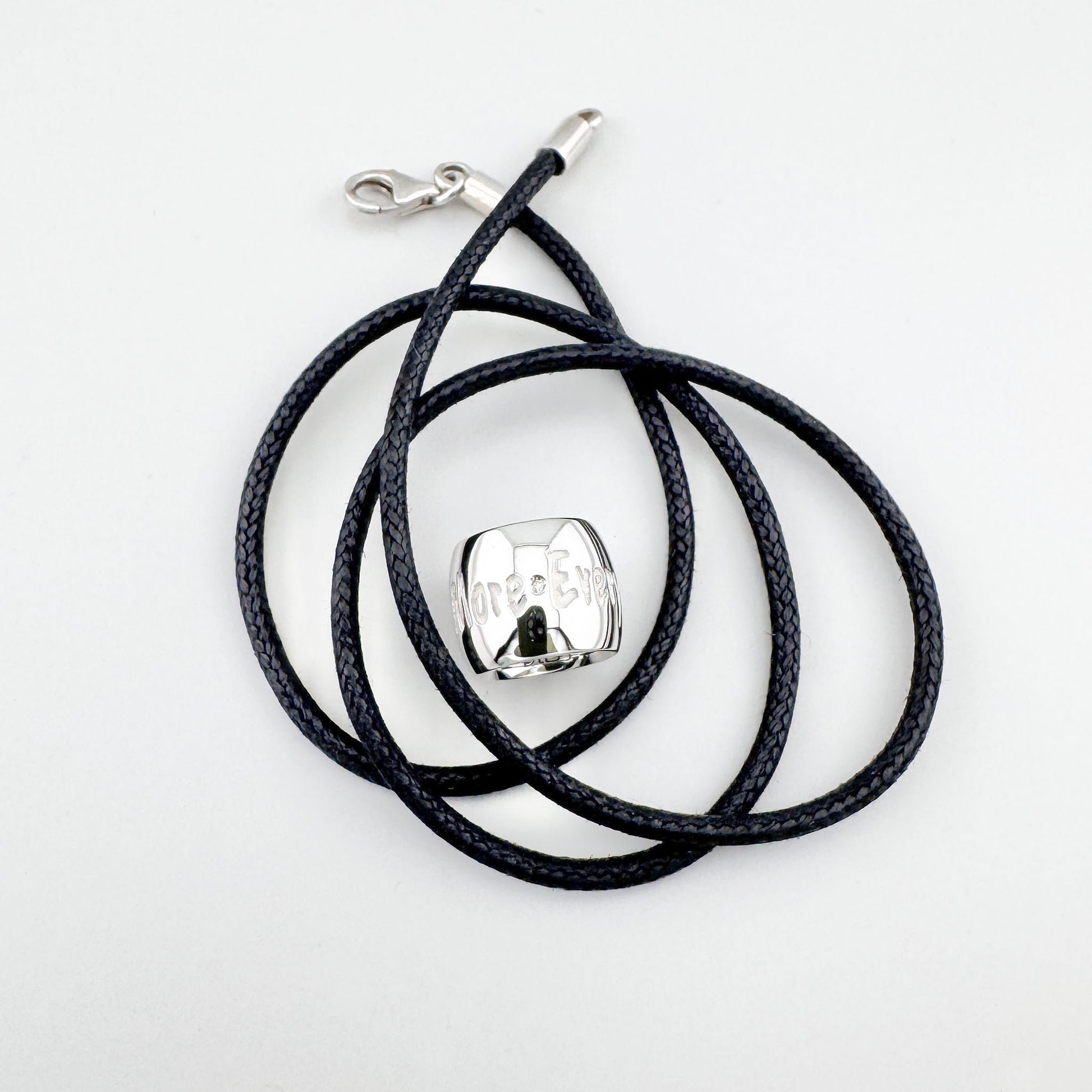 Naszyjnik z cylindryczną zawieszką na czarnym plecionym sznurku o minimalistycznym charakterze