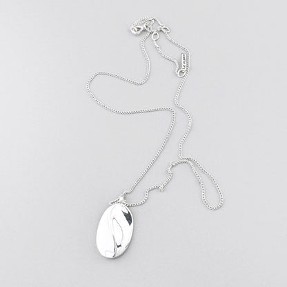 Feine Halskette mit ovalem Anhänger und glänzender Oberfläche im minimalistischen Stil