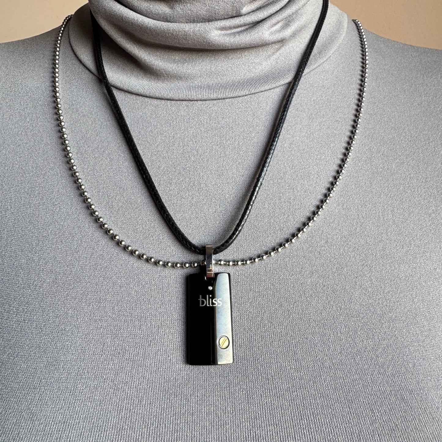 Double‑chain Bliss Gioielli necklace on neck, sleek steel shine paired with black cord for a modern look