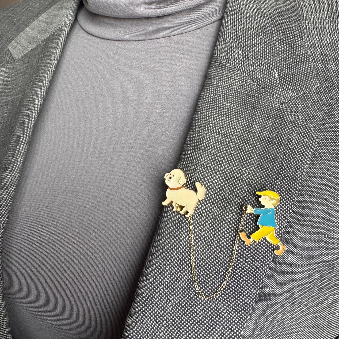 Double pin brooch Sonata worn on a blazer with a boy and dog motif