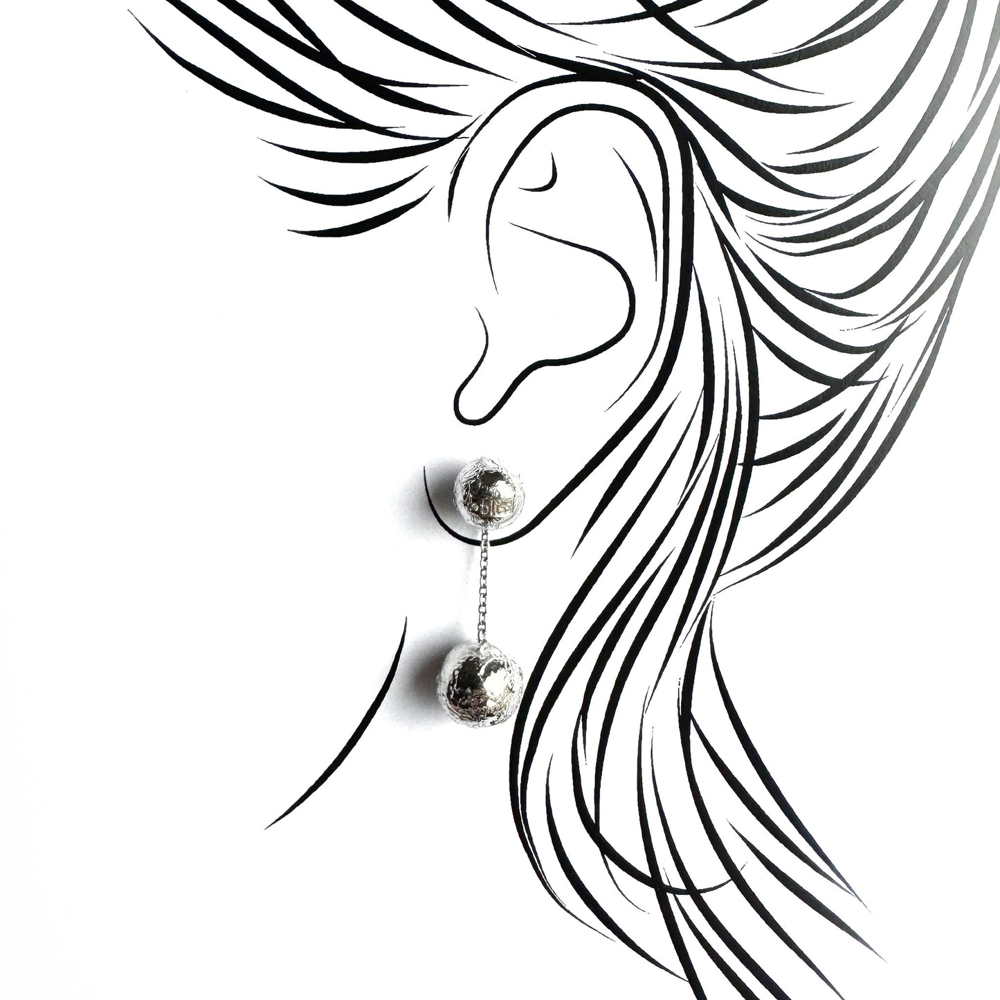 Ball drop earrings shown on an ear outline for a light, elegant silhouette