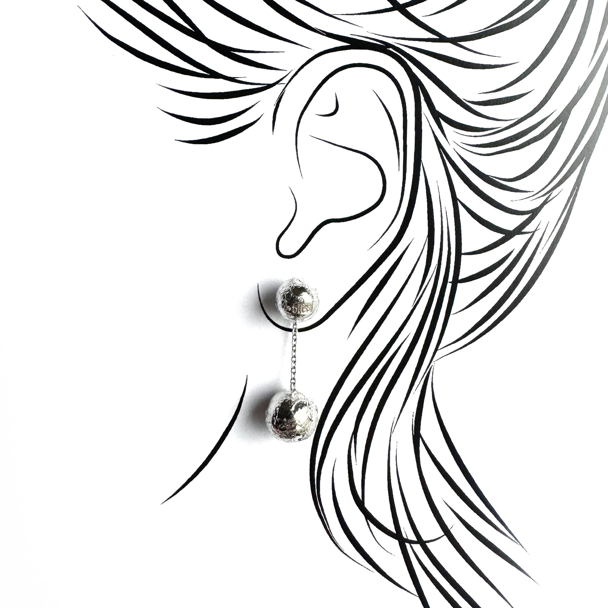 Ball drop earrings shown on an ear outline for a light, elegant silhouette