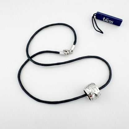 Srebrny naszyjnik z grawerem i diamentem na czarnym sznurku, spokojny akcent