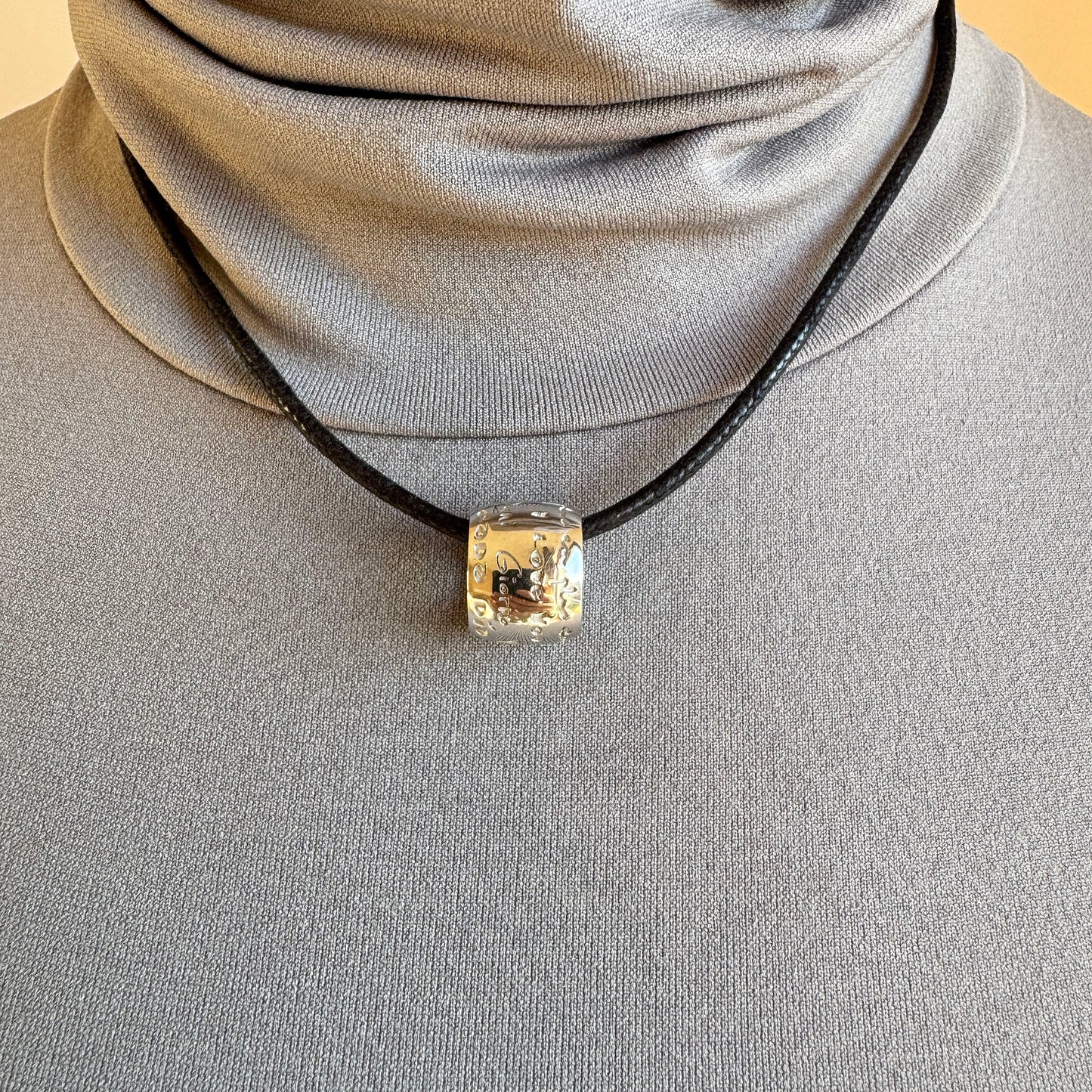 Engraved silver necklace with diamond on a black cord, a quiet modern accent