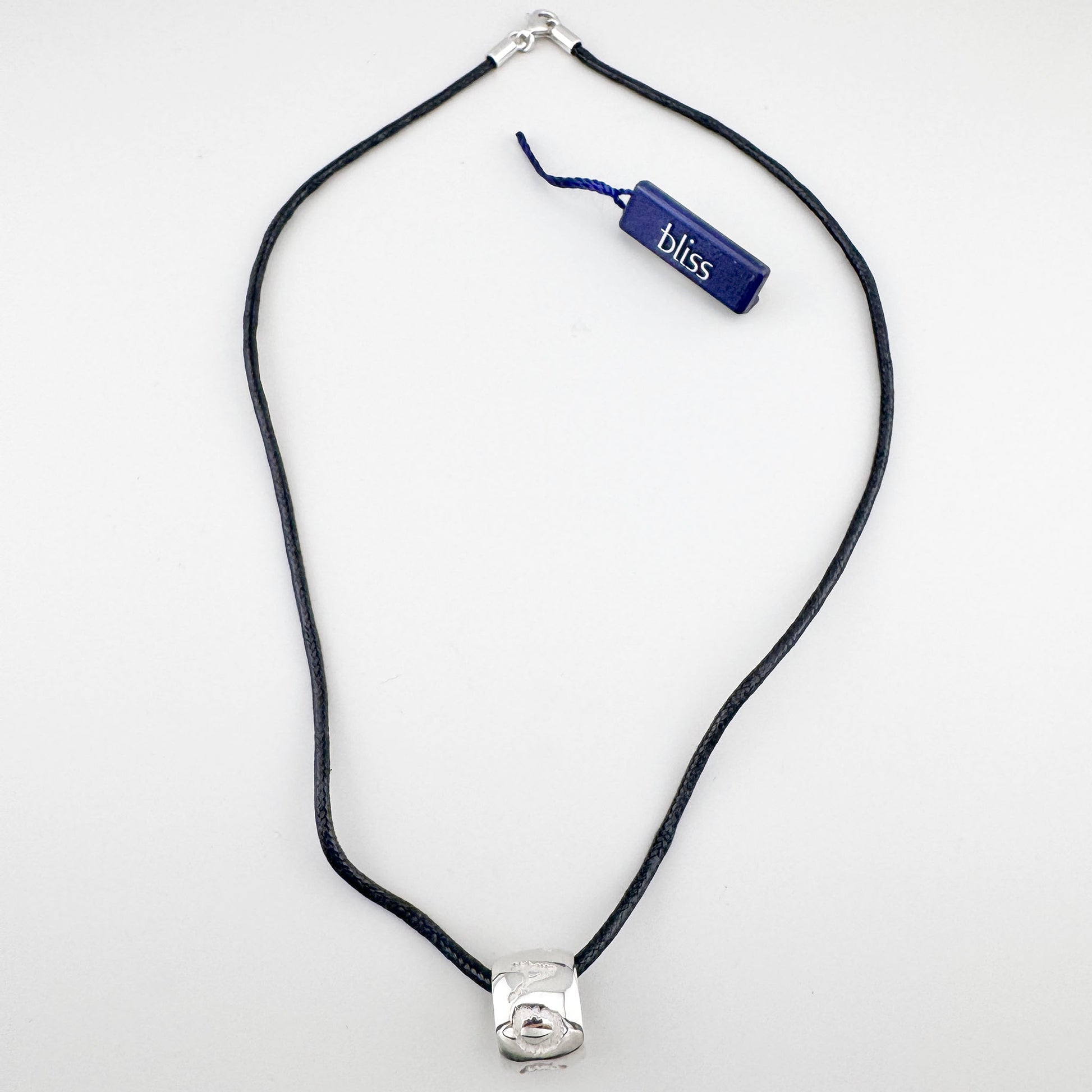 Naszyjnik z grawerowanymi symbolami na czarnym sznurku o spokojnym, znaczącym charakterze