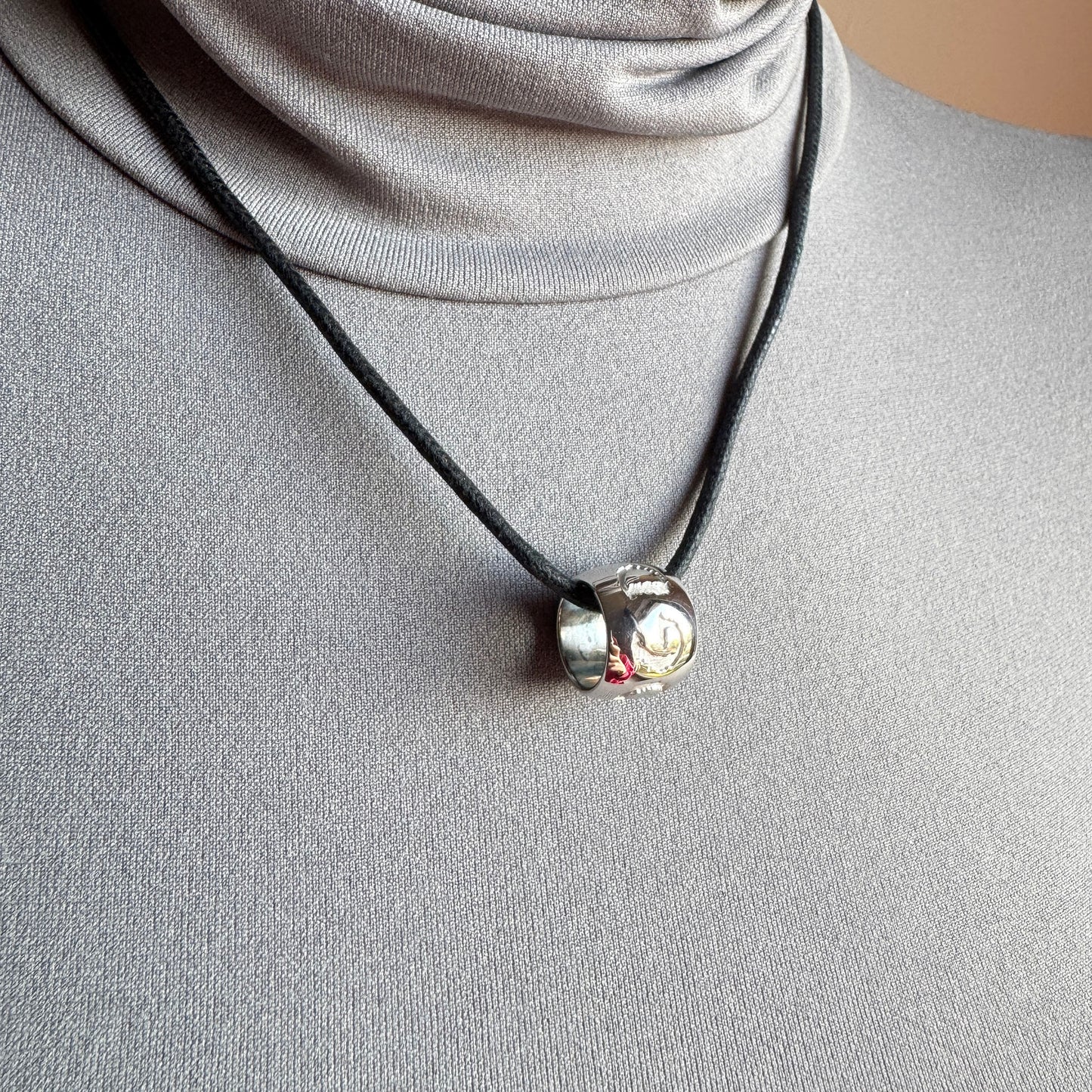 Halskette mit gravierten Symbolen und schwarzem Band, dezente moderne Ausstrahlung