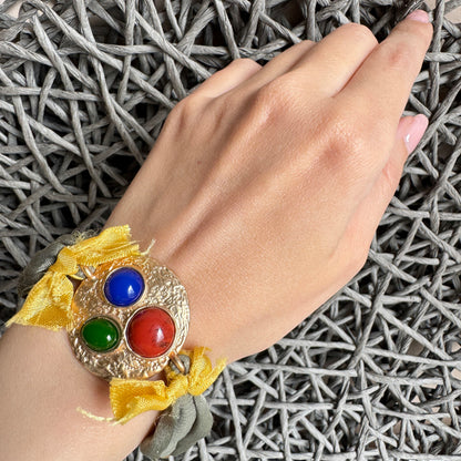 Sonata fabric bracelet with colorful cabochons and gold-tone hammered base worn on wrist