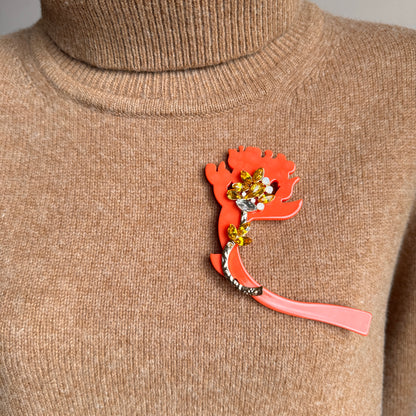 Bold orange acrylic flower brooch with yellow crystals on sweater