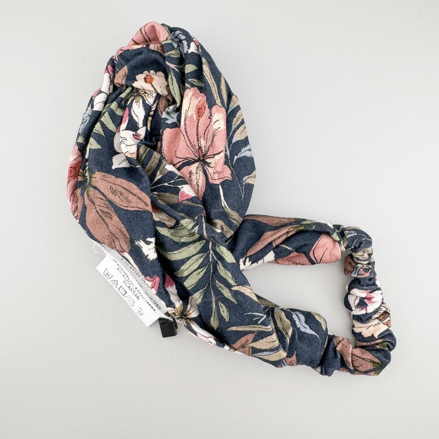 Floral IRL headband folded with a soft twisted shape and dark floral pattern