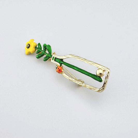 Broszka Sonata z żółtym kwiatem w butelce i małą biedronką na złotej oprawie