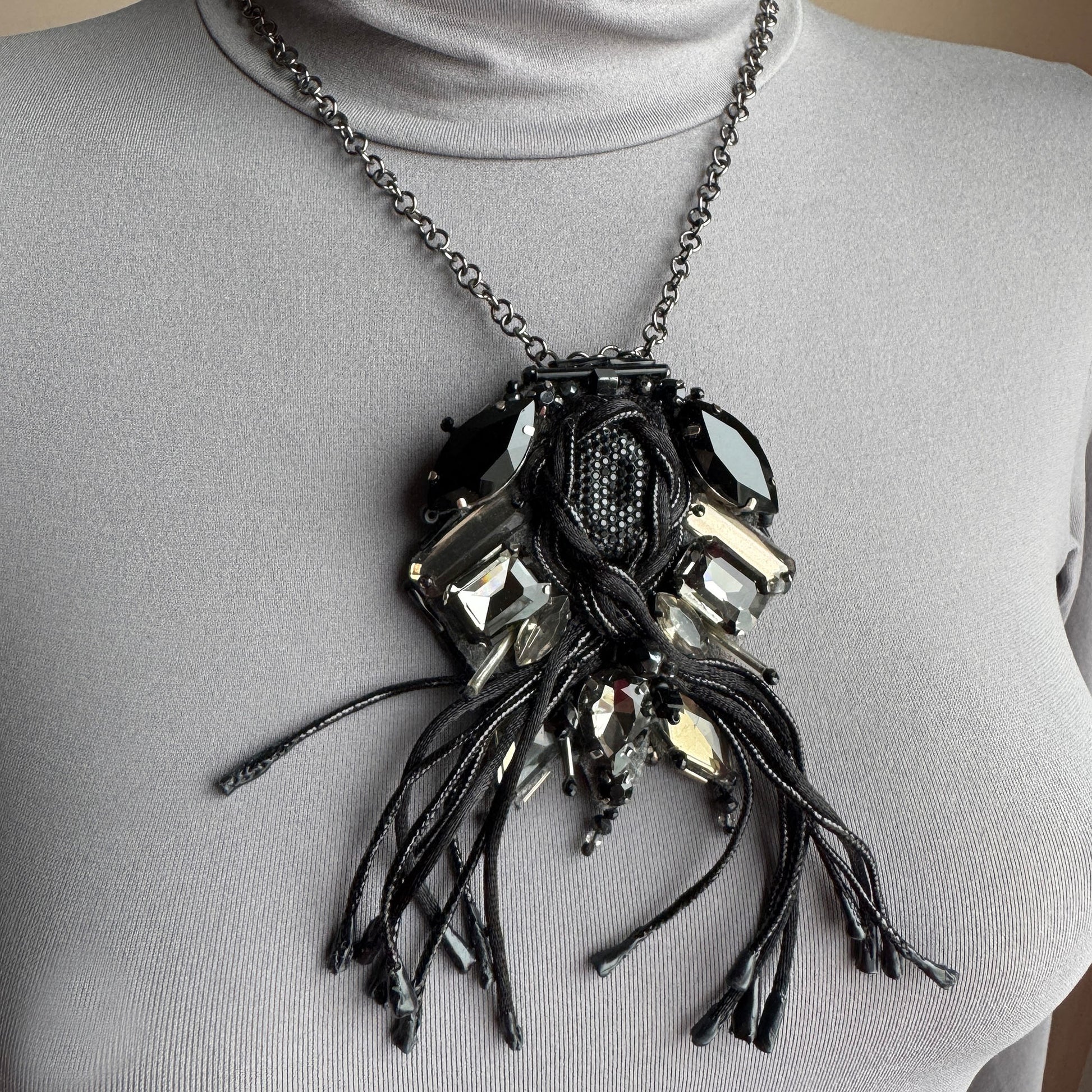 Artistic fringe brooch Sonata worn as a necklace with dark crystals and textile tassels