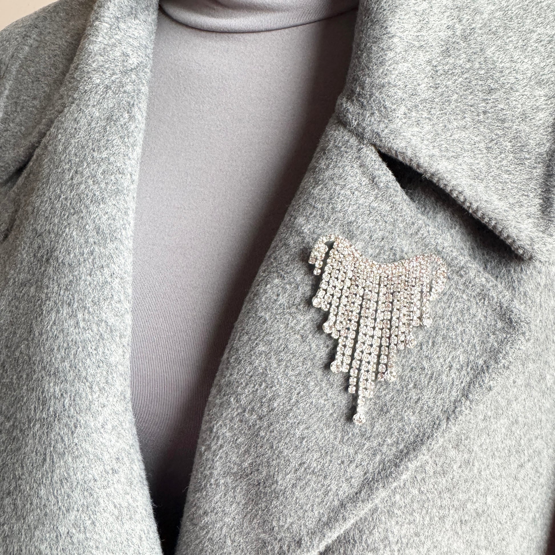 Silver fringe brooch Maravillas worn on a coat with a light-catching crystal cascade
