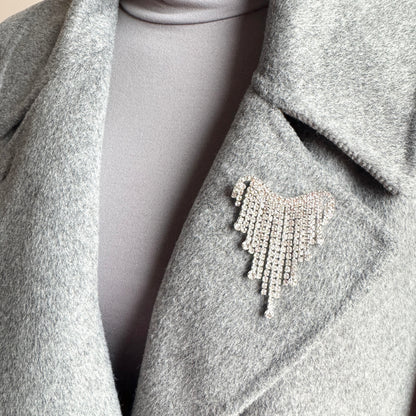 Silver fringe brooch Maravillas worn on a coat with a light-catching crystal cascade